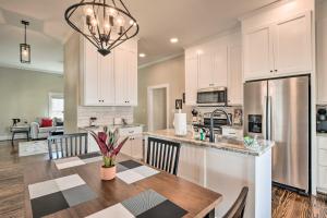 a kitchen with white cabinets and a wooden table with a dining room at Ideally Located Penne Place with Deck and Grill in Greenville