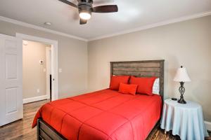 a bedroom with a red bed and a ceiling fan at Ideally Located Penne Place with Deck and Grill in Greenville