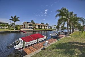 a boat is docked at a dock on a river at Pool and Canal Access Central Cape Coral Condo! in Cape Coral