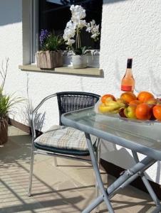 a table with a bowl of fruit and a bottle of wine at Großzügiges Zimmer mit Terrasse am Rheinsteig in Linz am Rhein