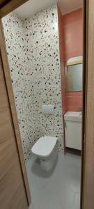 a bathroom with a toilet and a flower patterned wall at Apartman Blok 45 (reka Sava) in Belgrade