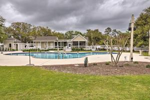 a swimming pool in front of a house at Cottage with Deck and Pool Access about 6 Mi to Beach in Myrtle Beach