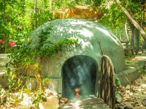 a dome house with a fire hydrant in a garden at Ekumal by Villas Duendes Rotamundos in Akumal