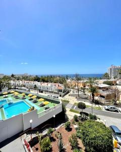 een balkon met uitzicht op het zwembad van een resort bij Sweet home deluxe in Playa de las Americas