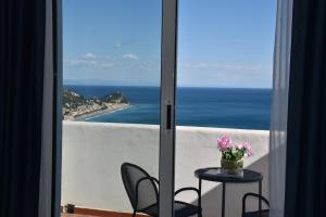 a view of the ocean from a balcony with a table and chairs at Hotel La Gioiosa in Finale Ligure