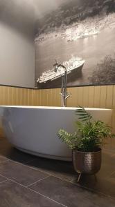 uma banheira numa casa de banho com uma fotografia de um navio de cruzeiro em Rose Villa em Oban