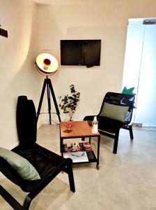 a living room with two chairs and a table and a tv at Residencial Douro in Peso da Régua