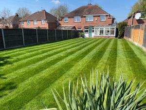 a large lawn in front of a house at Orion House - sleeps 6, driveway, garden in Crewe