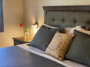 a bedroom with a bed with pillows and a vase with a flower at Strip Center Suites by Casona Lo Aguirre in El Monte