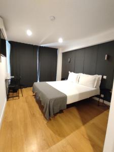 1 dormitorio con 1 cama grande y suelo de madera en Residencial Douro, en Peso da Régua