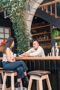 un hombre y una mujer sentados en un bar en Casa Tunki en Cuzco