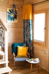 een kamer met een stoel, een tafel en een raam bij Eco Domki Podhalanka in Witów