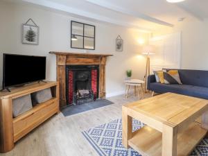 sala de estar con chimenea y sofá azul en Awelfa, en Newport