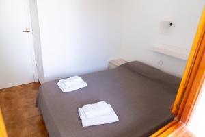 a bedroom with a bed with two towels on it at Apartamento Menorca Arenal d'en Castell in Arenal d'en Castell