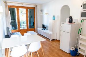 a kitchen with a white refrigerator and a table and chairs at Apartamento Menorca Arenal d'en Castell in Arenal d'en Castell