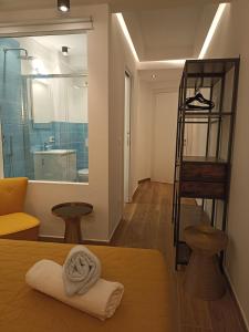 Al Porto 61 - Rooms for Rent في كامولي: غرفة بها منشفة على سرير وحمام