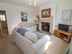 a living room with a white couch and a fireplace at 4 Alma Road in Buxton