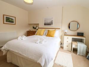 a bedroom with a white bed with towels on it at 4 Alma Road in Buxton