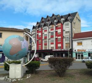 a statue of a globe in front of a building at San Remo World Hotel in San Clemente del Tuyú