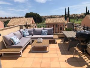 a patio with a couch and a table and a grill at Casa de Nio in Algorfa