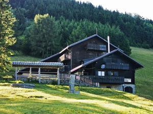 a large wooden building on a hill with trees at Planinski dom Vrhe in Trbovlje