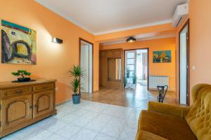 a living room with orange walls and a couch at Apartments Virna in Opatija