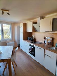 a kitchen with white cabinets and a table and a tableablish at Ferienwohnung Kreuzgasse in Bad Frankenhausen