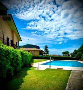 ein Schwimmbad in einem Hof neben einem Haus in der Unterkunft Welcome Traveller L'APPARTAMENTO DI ANNALISA in Garda