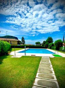 ein Schwimmbad in der Mitte eines Gartens in der Unterkunft Welcome Traveller L'APPARTAMENTO DI ANNALISA in Garda