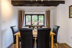 a dining room with a wooden table and chairs at Sunshine Cottage by Happy Sunshine Stay in Golborne