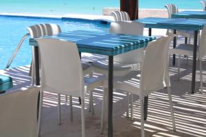 カンクンにあるCyan Cancun Resort & Spaのスイミングプールの横に青いテーブルと椅子