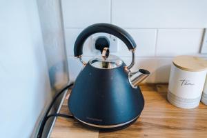 a blue tea kettle sitting on a counter with a cup at Sunshine Cottage by Happy Sunshine Stay in Golborne