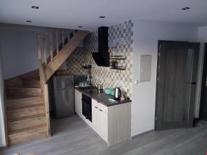 a kitchen with a sink and a refrigerator and a staircase at Wrzosowisko Sominy in Sominy +23 photos
