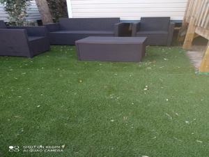 une cour avec un canapé et une table dans l'herbe dans l'établissement MOBIL HOME CAMPING LES SABLES DU MIDI, à Valras-Plage