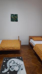 a room with two beds and a rug on the floor at Zeynep Apartments in Sarajevo