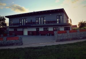 a large white building with a fence in front of it at Vinařský penzion Přední Hora in Velké Bílovice