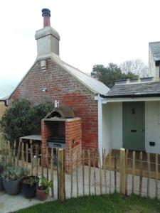 ein Backsteingebäude mit einem Backofen vor einem Haus in der Unterkunft Tiny Cottage for couples in the countryside in Shalfleet