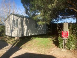 a small house with a sign in front of it at Camping l’r pur in Saint-Vincent-sur-Jard