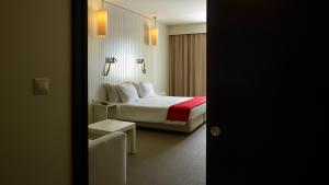 a hotel room with a bed and a mirror at Hotel Flor De Sal in Viana do Castelo