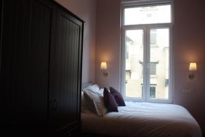 a bedroom with a bed and a large window at EU B&B in Brussels