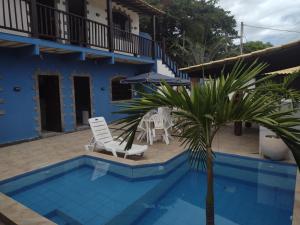 a villa with a swimming pool and a palm tree at Pousada MK TOUR in Pedra de Guaratiba