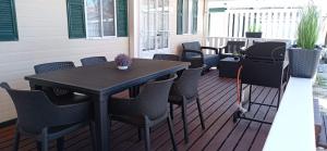patio ze stołem i krzesłami na tarasie w obiekcie Veni Mobilház w mieście Privlaka