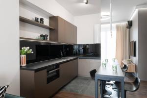 a kitchen with white cabinets and a black counter top at Apartamenty DES-Zator in Zator
