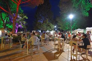 a group of people sitting at tables at night at Lux D'Or Apartment in Pula