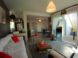 ein Wohnzimmer mit einem weißen Sofa und einem Tisch in der Unterkunft Gite les bambous en BAIE DU MONT ST MICHEL in Dragey
