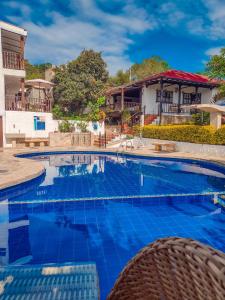duży basen z niebieskimi płytkami przed domem w obiekcie Hotel Casona del Virrey w mieście Moniquirá
