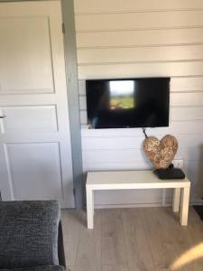 un soggiorno con TV e tavolo bianco di Rockschapel Cabin 30B a Annacloy