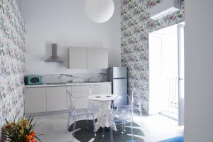 a kitchen with a table and chairs in a room at Corso Vittorio Elegant Suites Lipari in Lipari