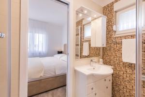 bagno con letto, lavandino e specchio di HOUSE MATIJA a Kaštel Stari