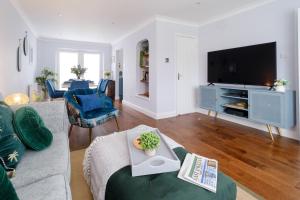 a living room with a couch and a tv at 2 Hillcrest - Aldeburgh Coastal Cottages in Leiston